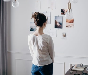 person looking at a wall of pictures