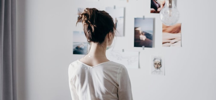 person looking at a wall of pictures